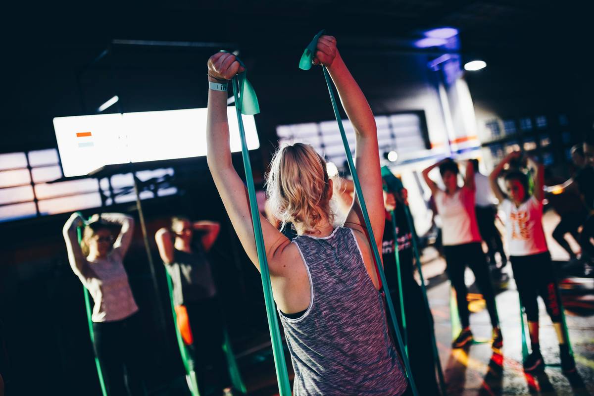 Woman performing iron burn fitness routine with kettlebell swing in home gym