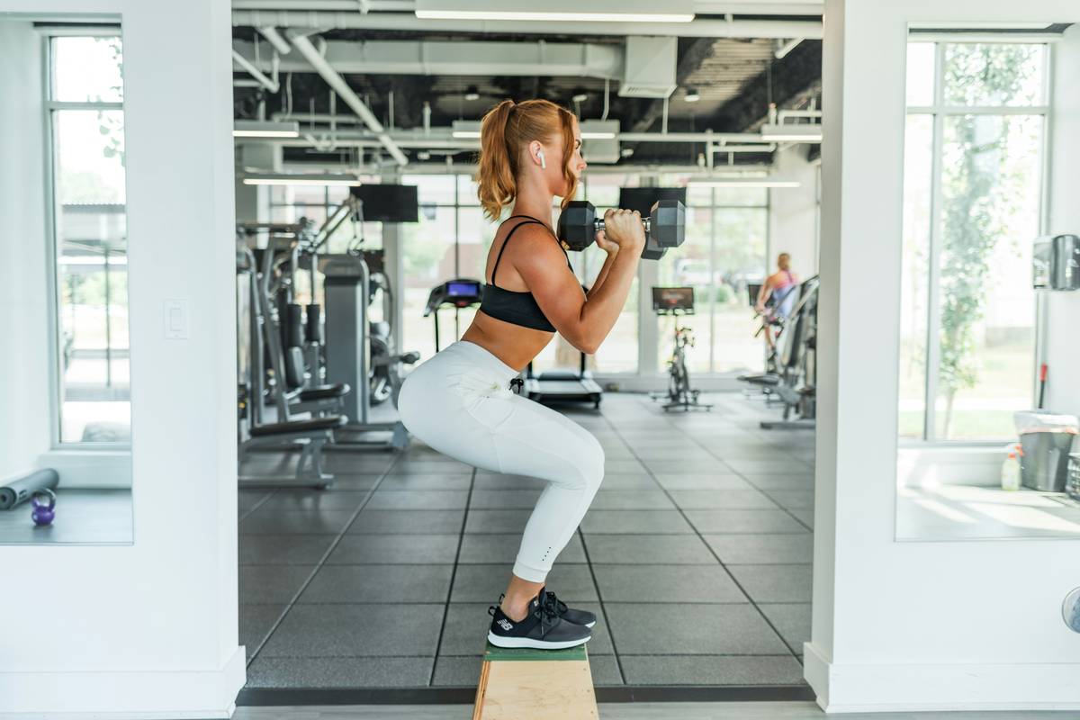 Woman performing proper kettlebell swing as part of kettlebell burn program plan